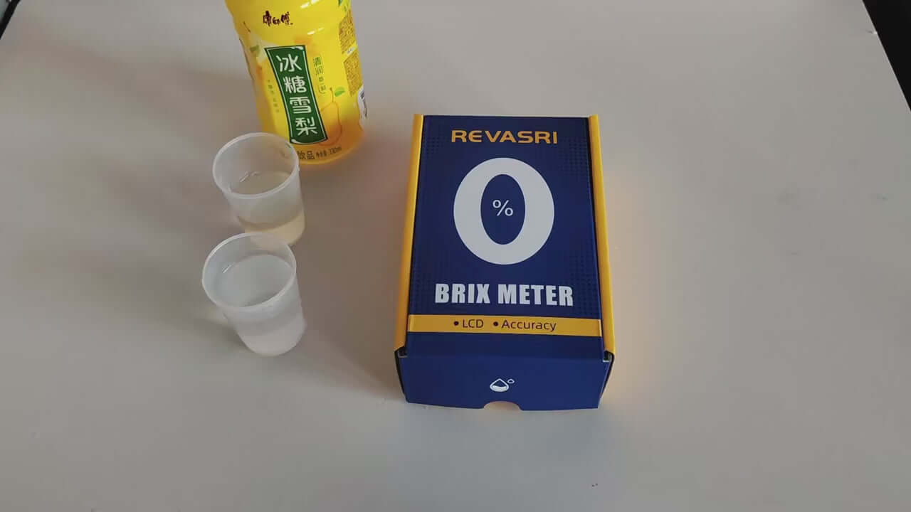 REVASRI Rechargeable Digital Brix Refractometer Meter box with liquid samples on a table, ideal for measuring sugar content.